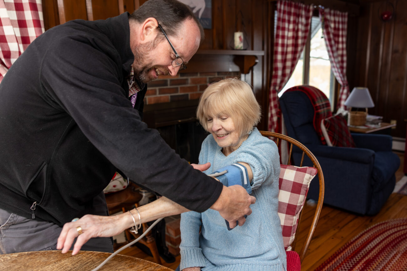 Nurse putting blood pressure cuff on patient